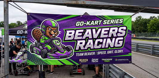 Custom 3x6 racing team vinyl banner hung on a 10x10 canopy tent at the track, printed by Beaver Slaps