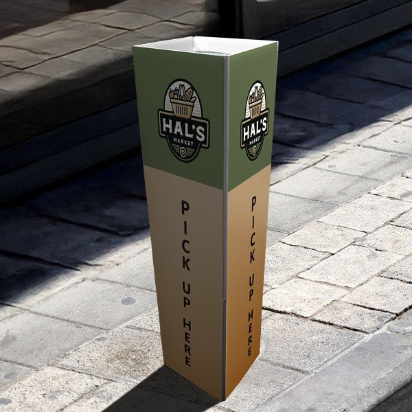 Bollard cover with logo and Pick Up Here printed on each face, on a sidewalk
