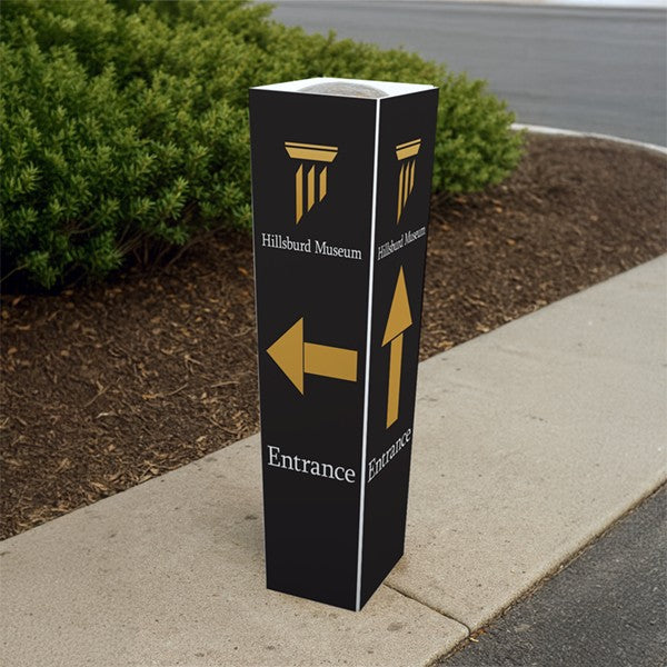 Black bollard cover with gold entrance arrows for wayfinding